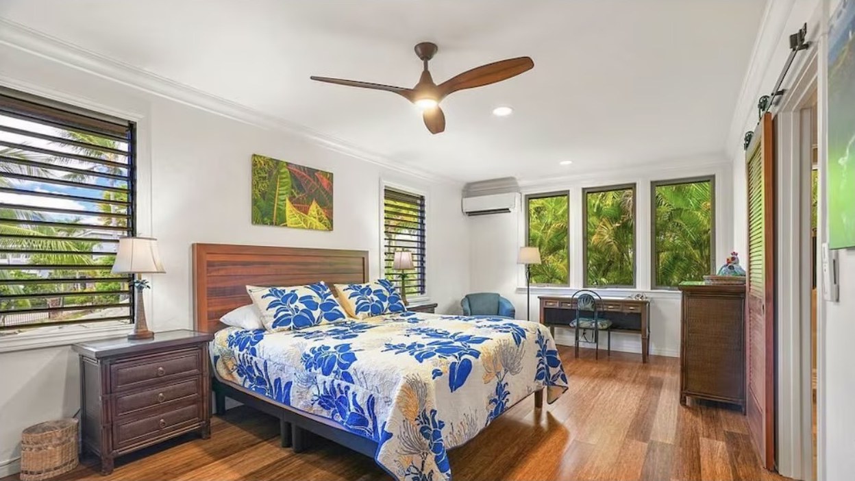 Primary Bedroom, king bed with windows on two sides looking into the palms